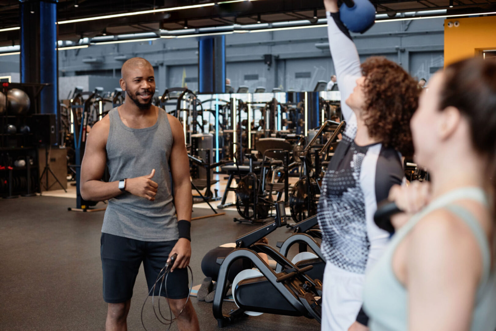 People exercising with a trainer in gym.